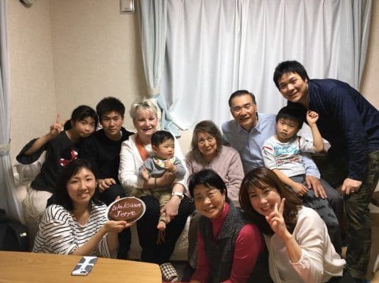 2018年、日本で再会したジェリー・バローさんとナルミ・イケザワさん、その家族の集合写真。Welcome Jerreと書かれた飾りも写っている